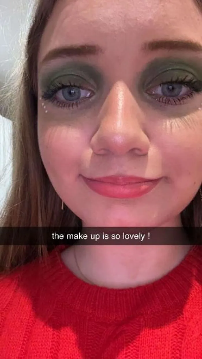 Close-up of a woman wearing stage makeup with green eyeshadow and red lipstick, showcasing magical stage makeup looks.
