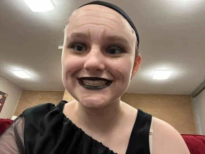 Person with stage makeup featuring exaggerated dark lips and wrinkles, showcasing magical yet mildly cursed stage makeup look.