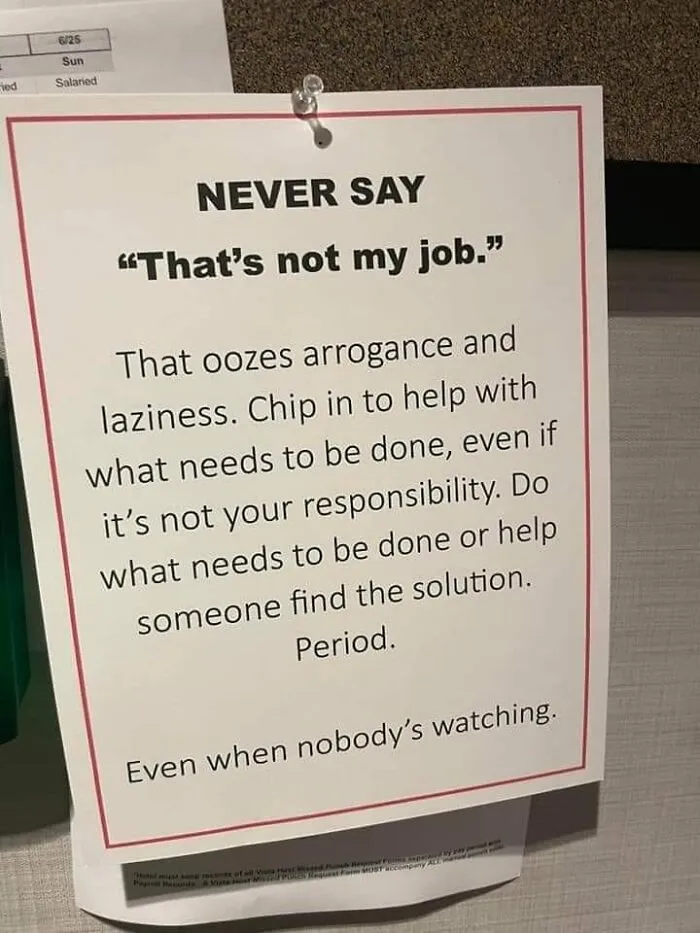 Sign advising against saying "That's not my job," urging responsibility and teamwork in a dystopia work environment.