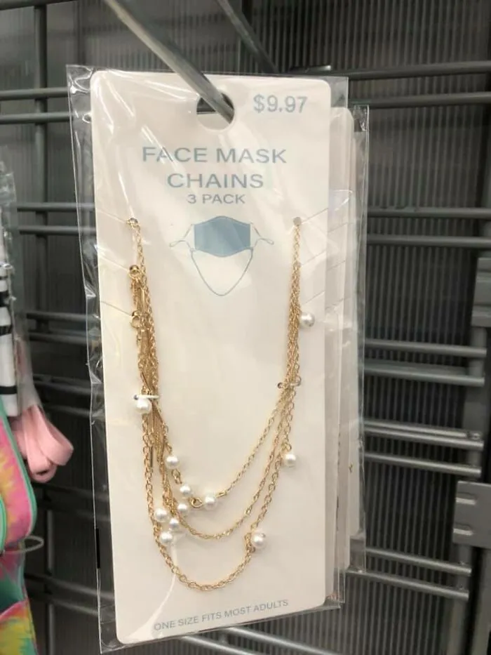 Face mask chains in gold with pearls, packaged for sale, highlighting dystopia themed everyday products.