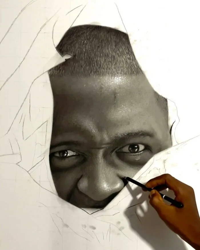 Artist’s hand drawing hyperrealistic portrait of a man’s face with intense eyes coming to life on paper.
