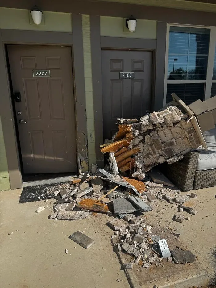 Broken wall debris scattered outside apartment doors illustrating unfortunate events and mishaps.