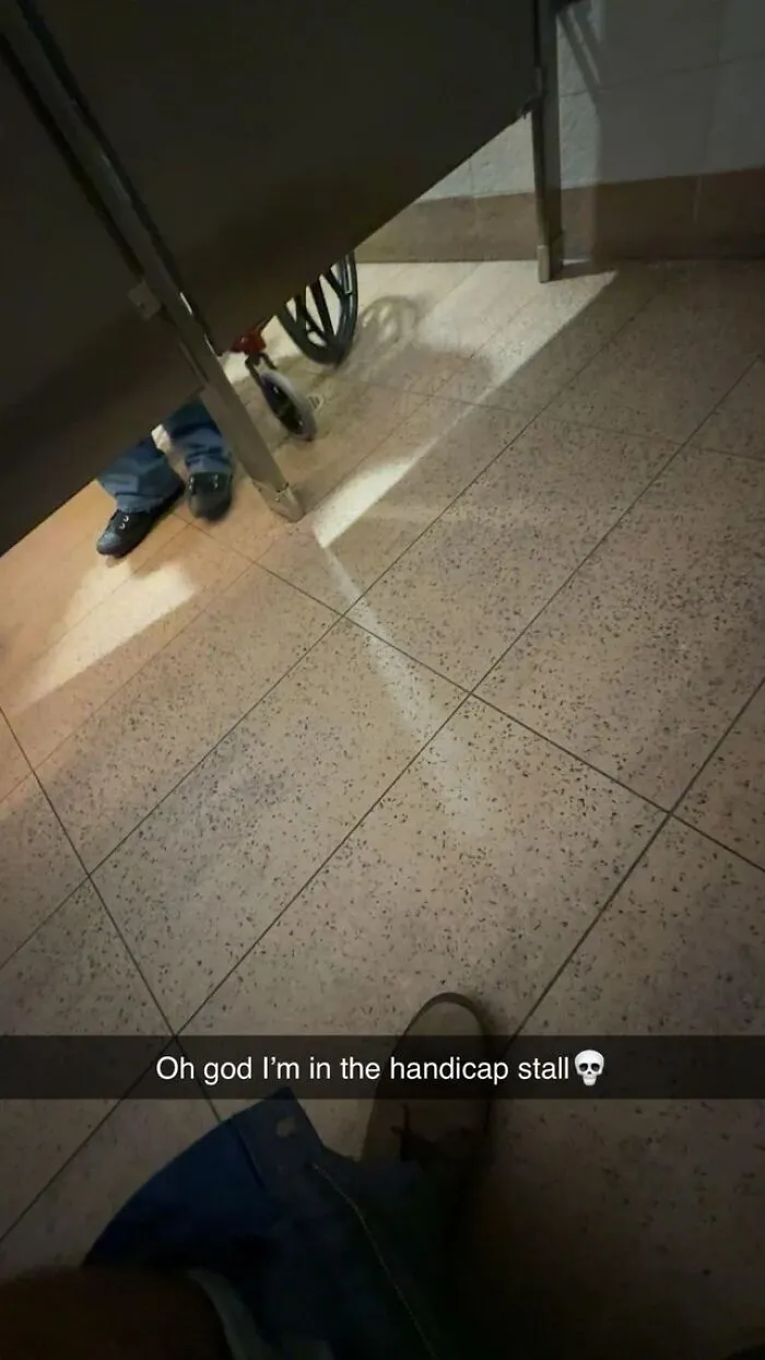 Person stuck in a handicap stall with a wheelchair visible nearby in an unfortunate event photo.