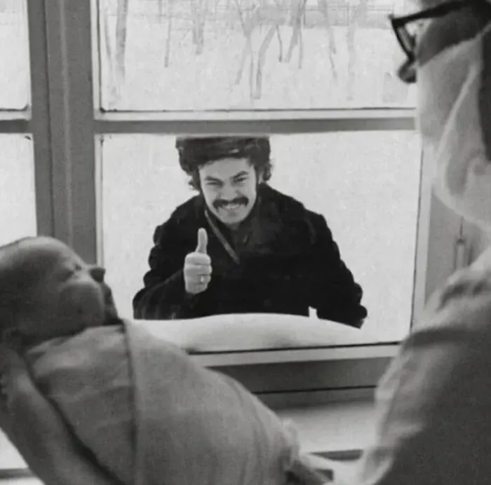 A Beaming New Dad Is Pictured Giving His Newborn Child Thumbs-Up From Outside A Window. Soviet Union 1977