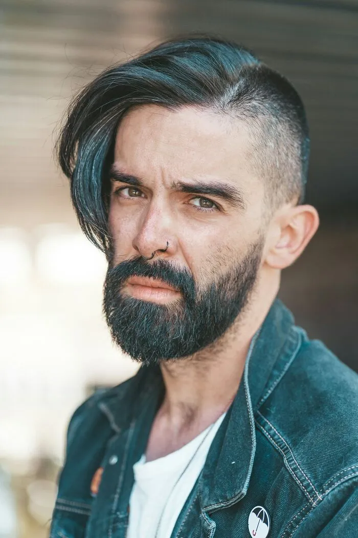 Close-up portrait of a man with a beard and styled hair, reflecting the experience of former cult members.