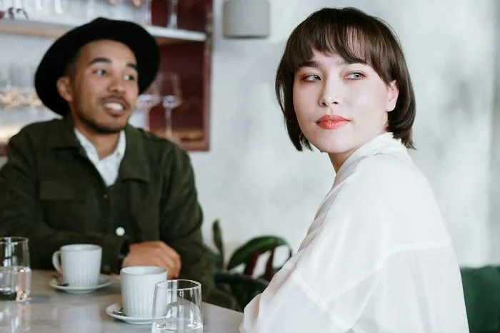 Two people sharing a hopeful moment over coffee, representing uplifting stories of progress and hope in America.