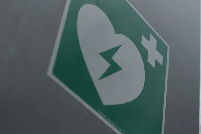 Close-up of a first aid defibrillator sign symbolizing hope and progress in America beyond negative headlines.