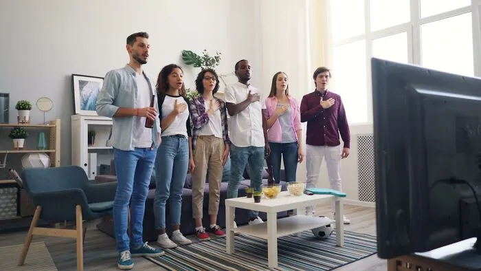 A group of friends sharing local inside jokes and laughing together in a cozy living room setting.
