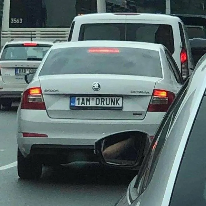 White Skoda Octavia with a humorous personalized license plate reading 1AM DRUNK in a traffic jam, Eastern European experience.