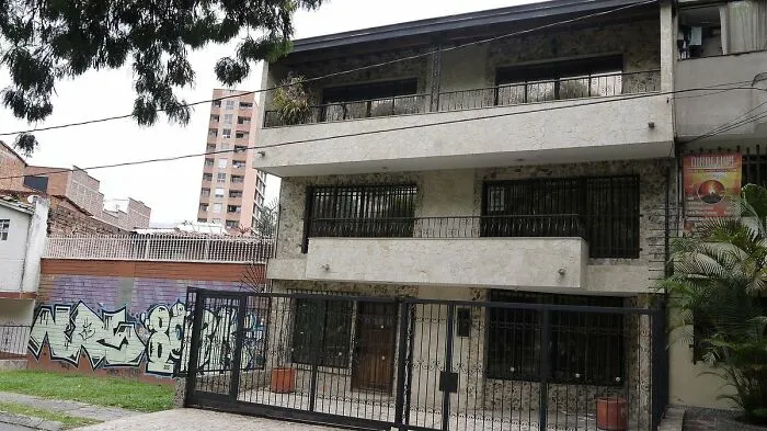 Urban residential building with graffiti on adjacent wall, representing disappointing tourist attractions locals often overlook.