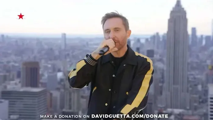 DJ performing on rooftop with city skyline in background, capturing a pop culture moment that made people cringe hard.