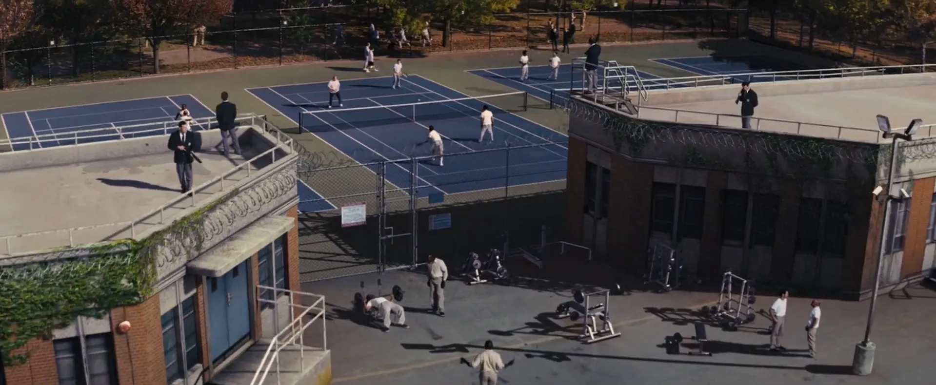 Prison yard scene with inmates exercising and playing basketball, from a movie final scenes part 3.