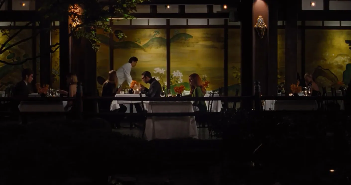 Couples seated at tables in a dimly lit restaurant with an Asian-inspired painted screen in the background.
