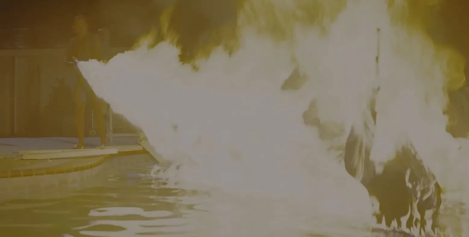 A person using a flamethrower near a pool with large flames in a dramatic movie final scene part 3.