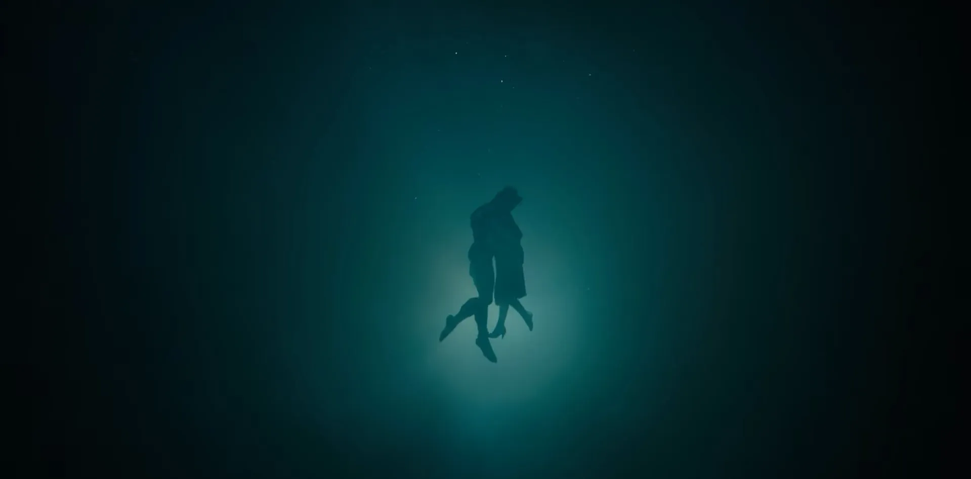 Silhouetted figures underwater in a deep blue scene, evoking a dramatic movie final scene atmosphere.