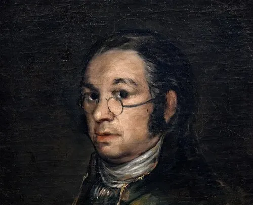 Portrait of Spanish painter Francisco Goya wearing glasses and dark clothing against a dark background.