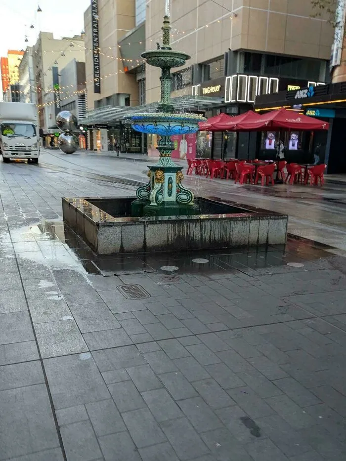 The Pool Of The Fountain At My Local Mall Is Too Small To Catch Its Water, Creating A Slip Hazard Around It