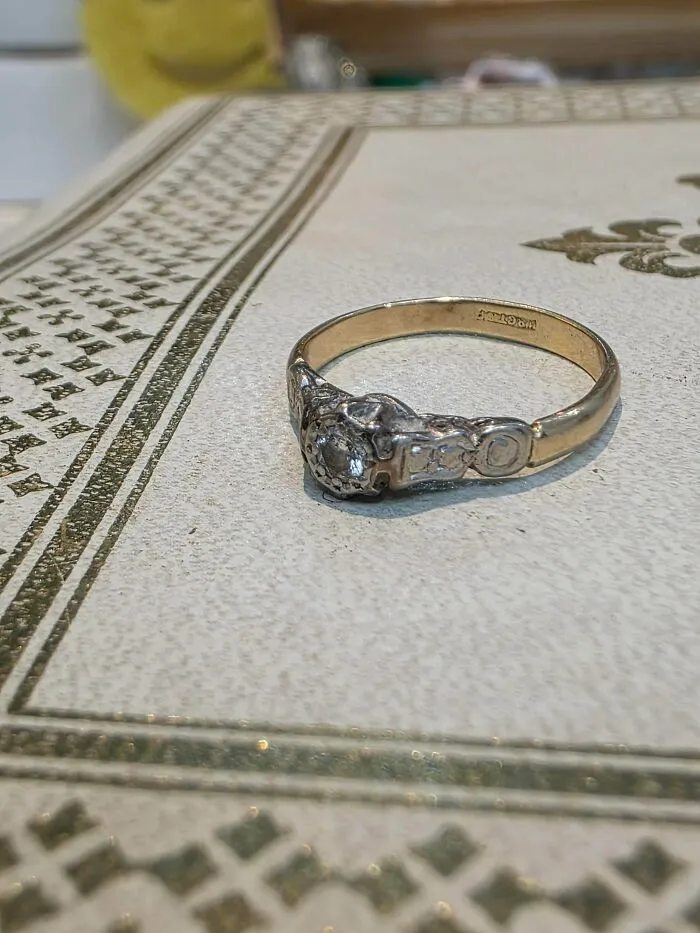 An antique-looking gold ring with several small diamonds, a precious item discovered while dumpster diving.