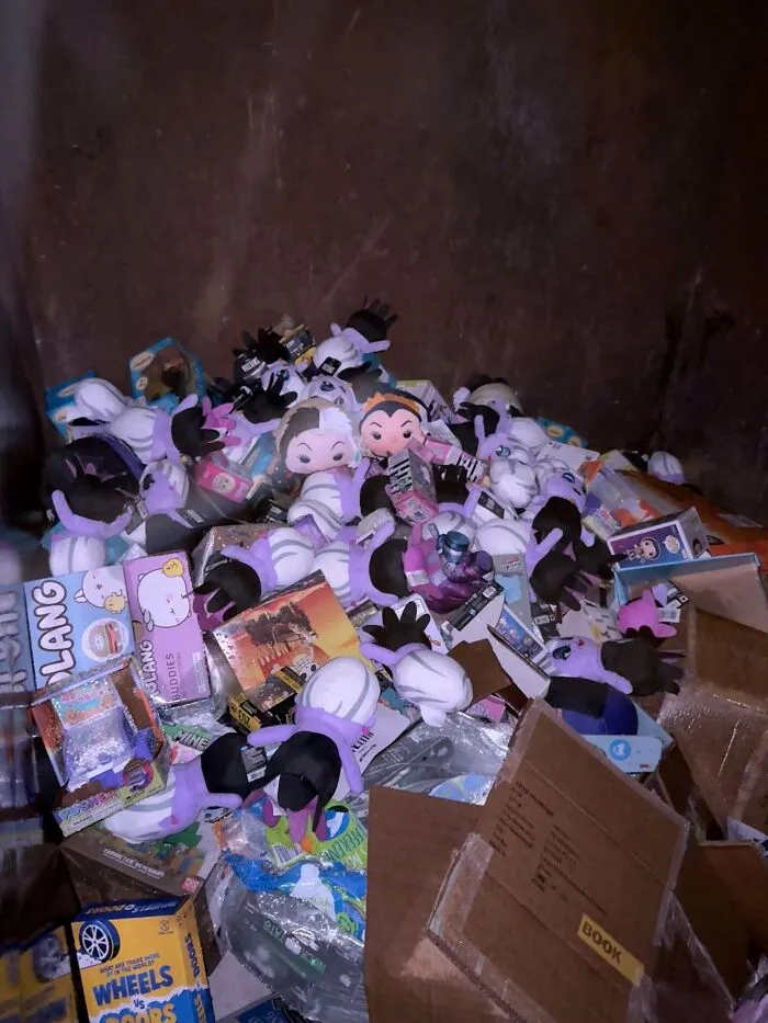 A large pile of plush toys and boxed items filling a dumpster, a jackpot for dumpster diving.