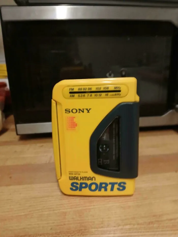 A yellow Sony Walkman Sports, a vintage electronic device, found while dumpster diving.