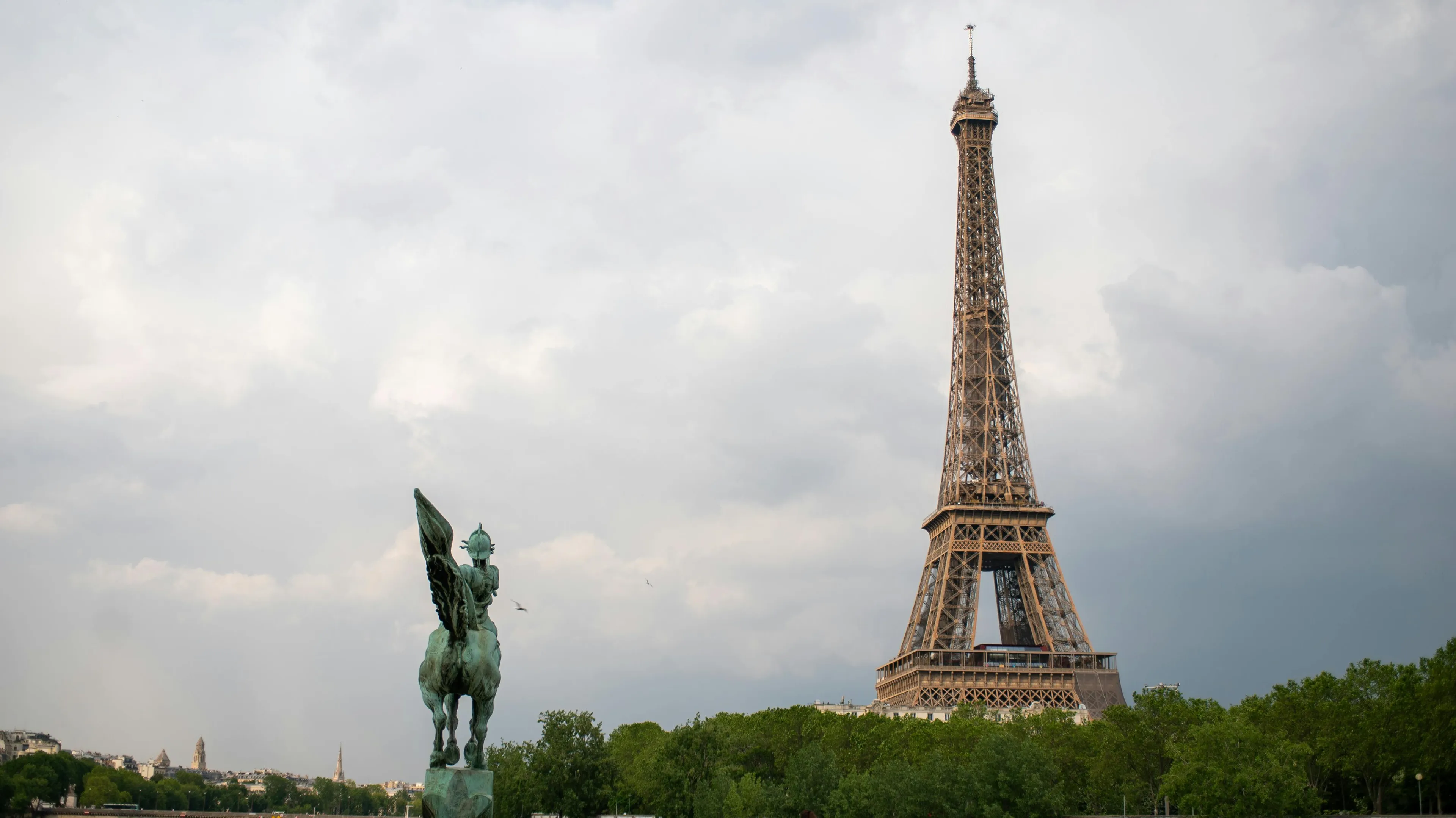 Eiffel Tower in Paris with cloudy sky, not to be confused with ancient site in France famous for prehistoric cave paintings.