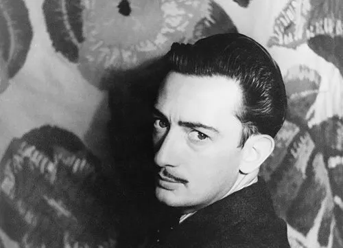 Salvador Dalí portrait in front of surrealist art, representing the art movement most strongly associated with him.