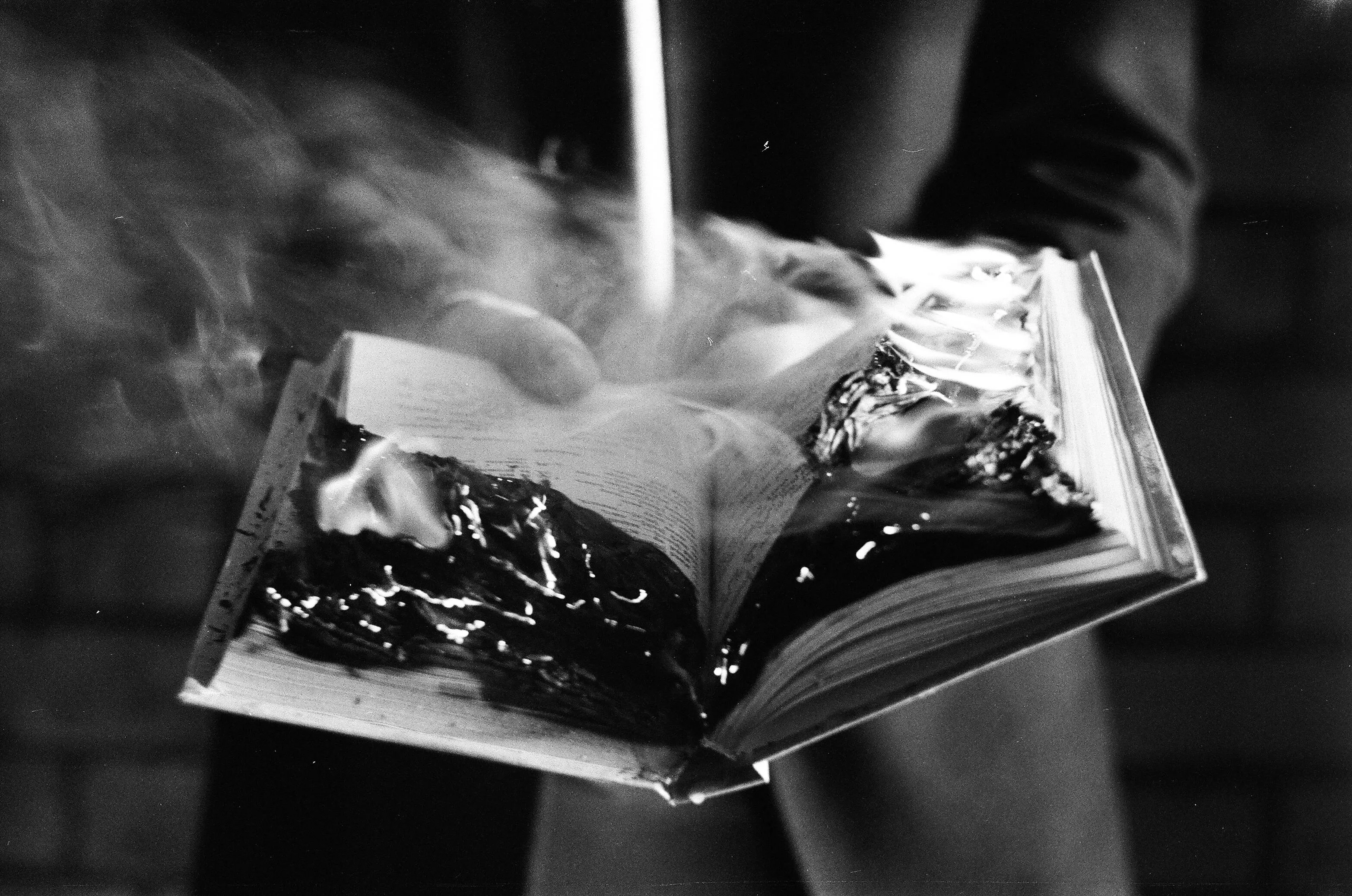 Burning book with flames and smoke, symbolizing the historical figure who burned books and buried scholars in ancient China.