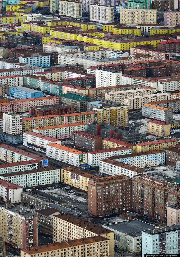 Aerial view of dense, colorful apartment blocks illustrating dystopian urban hell and the true price of modern life.