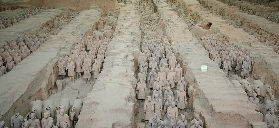 Rows of ancient terracotta clay soldiers standing guard in the tomb of an emperor, part of the terracotta army site.
