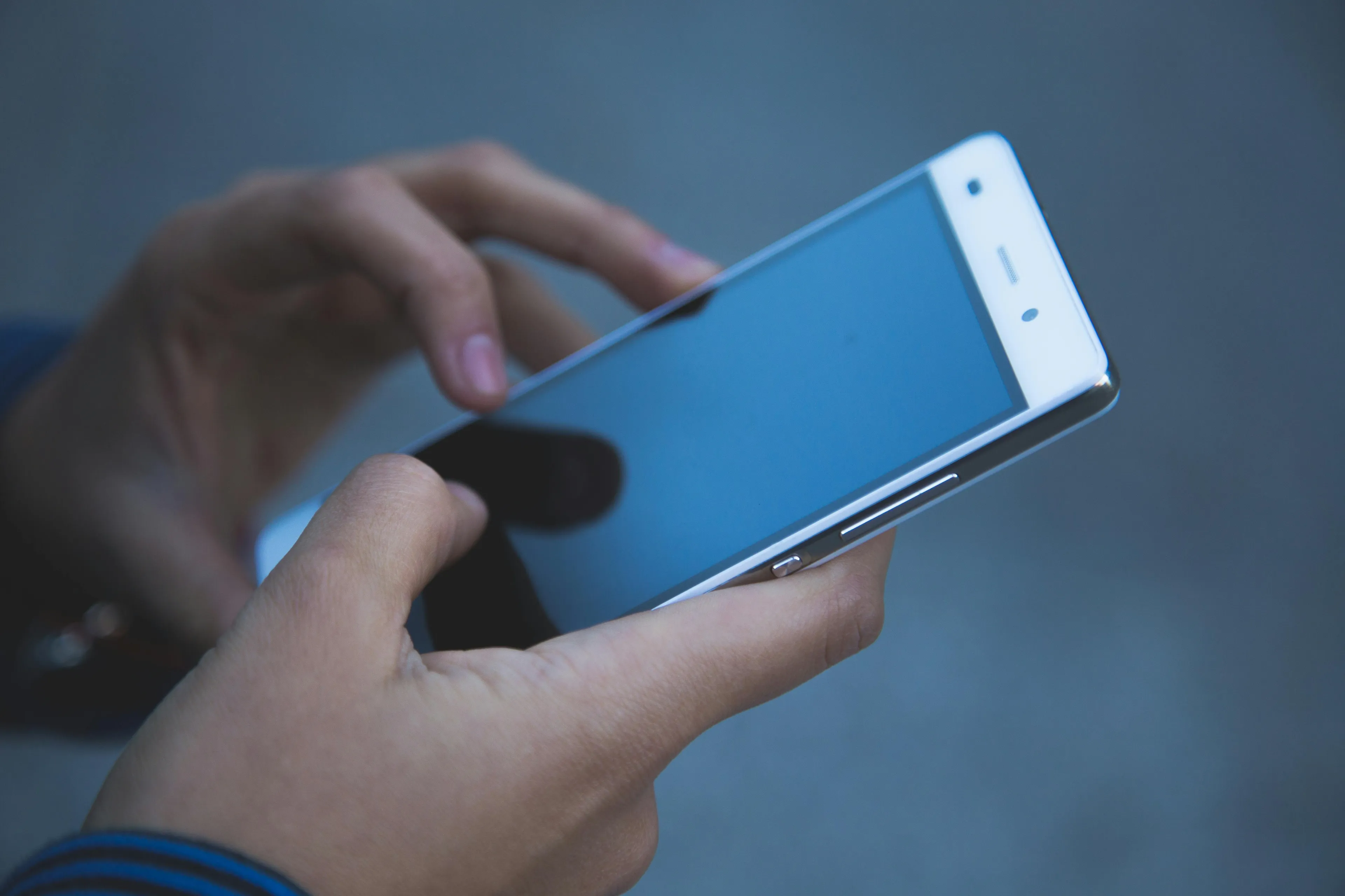 Person holding a smartphone with a black screen, illustrating fear of being without your phone concept.
