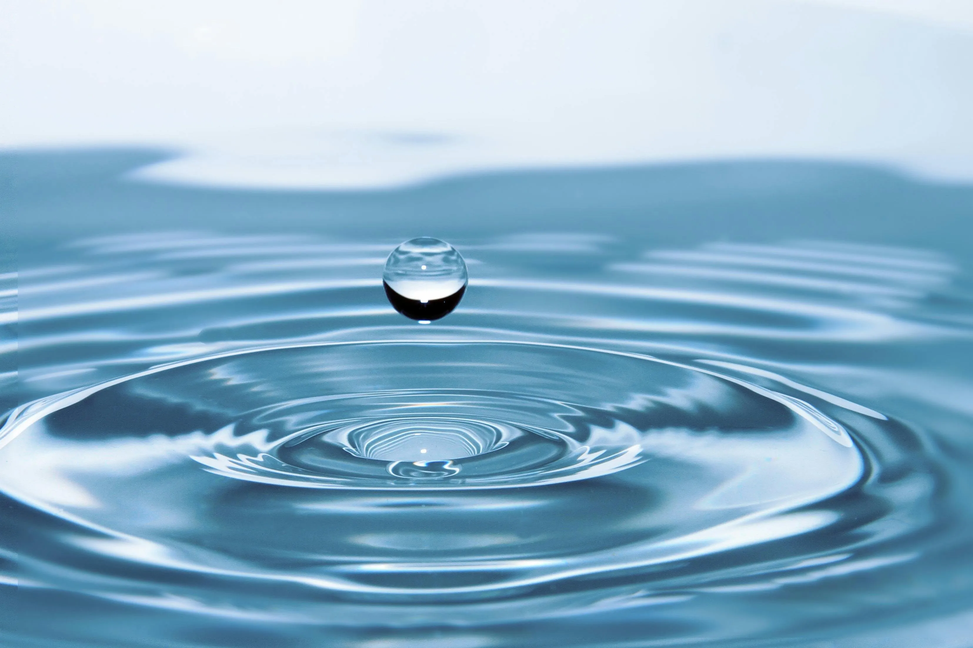 Water droplet creating ripples on surface, illustrating movement in the branch of science studying air and water motion