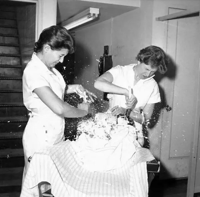 Estudiantes de la escuela de barbería intentando afeitar un globo, 1959