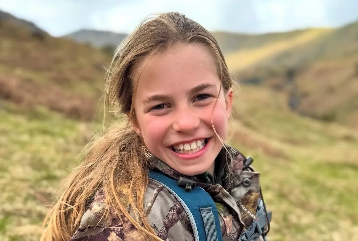 Princess Charlotte smiling outdoors in casual attire, embodying the spirit of a modern people’s princess.