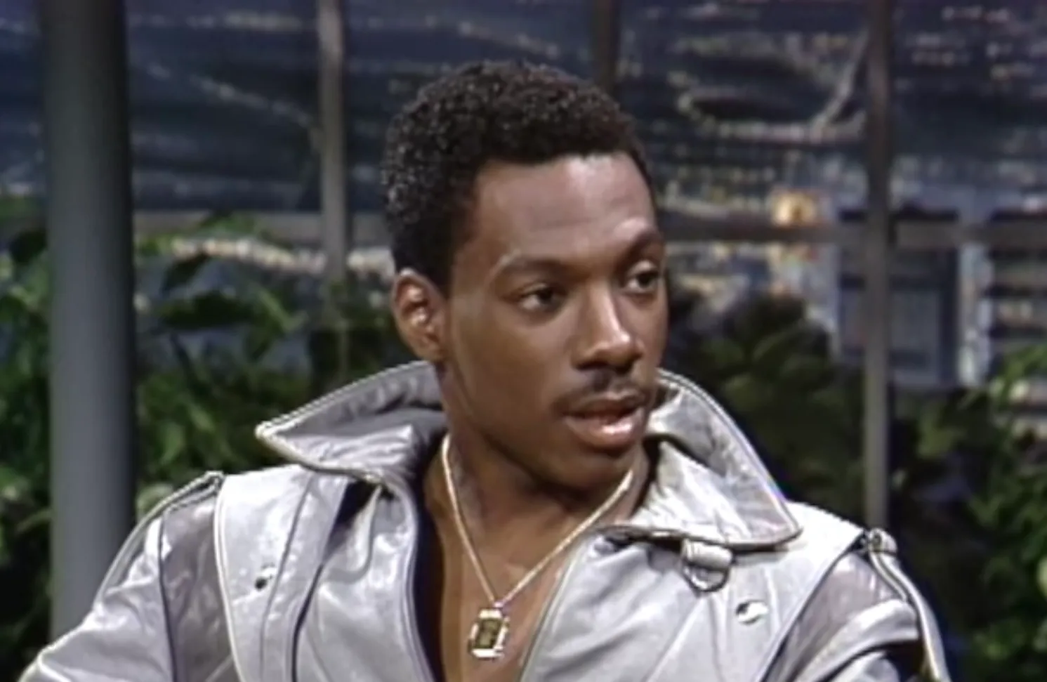 Comedian and actor from the 80s known for Saturday Night Live and Beverly Hills Cop wearing a silver jacket.