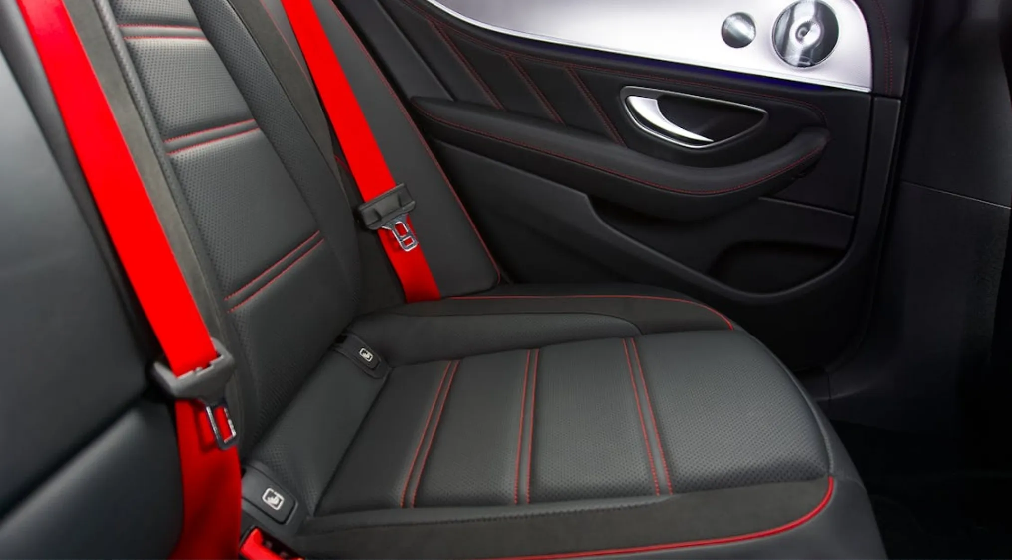 Car backseat with red seatbelt highlighting physics concepts of protection during sudden stops.