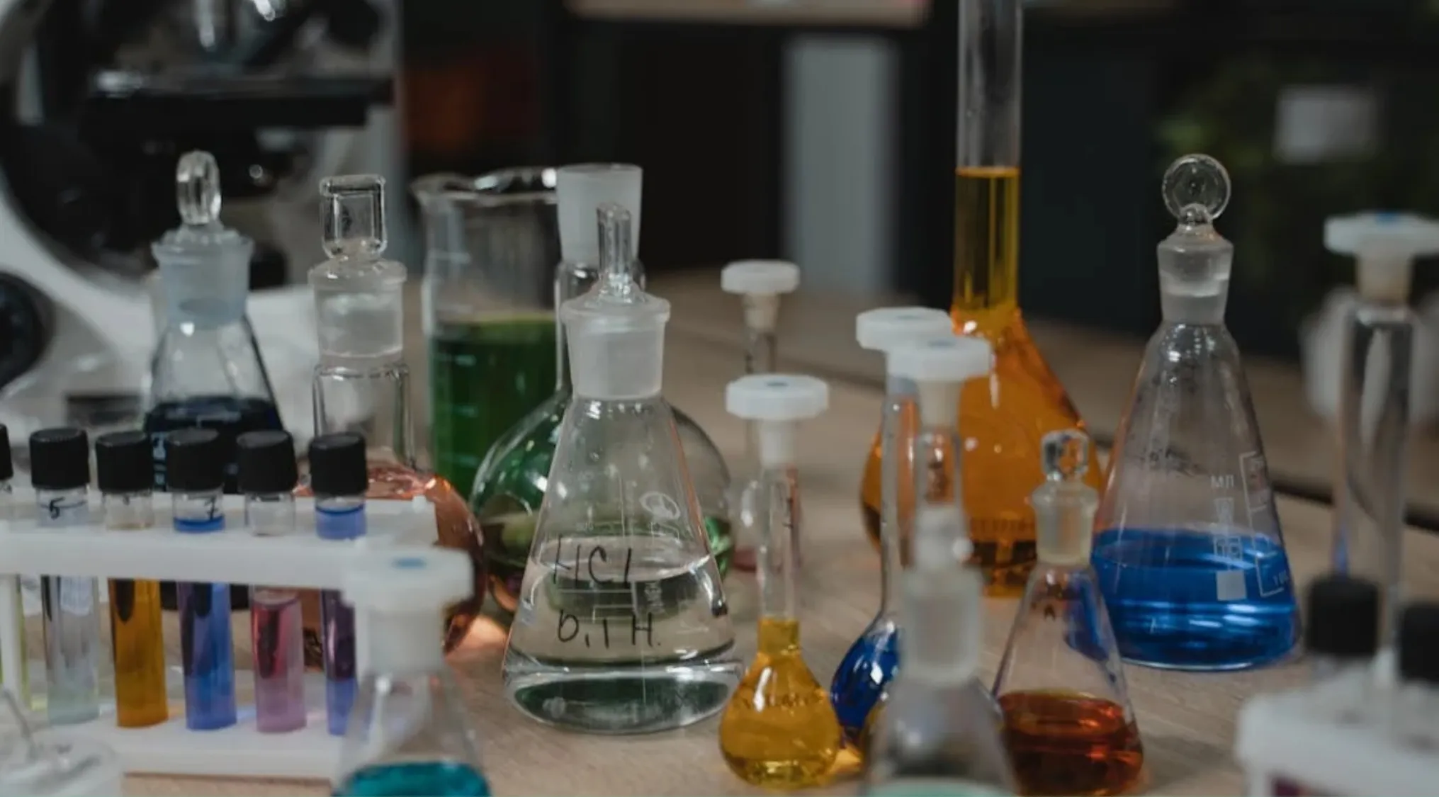 Various chemistry glassware with colorful liquids demonstrating how a catalyst affects a chemical reaction in a lab setting