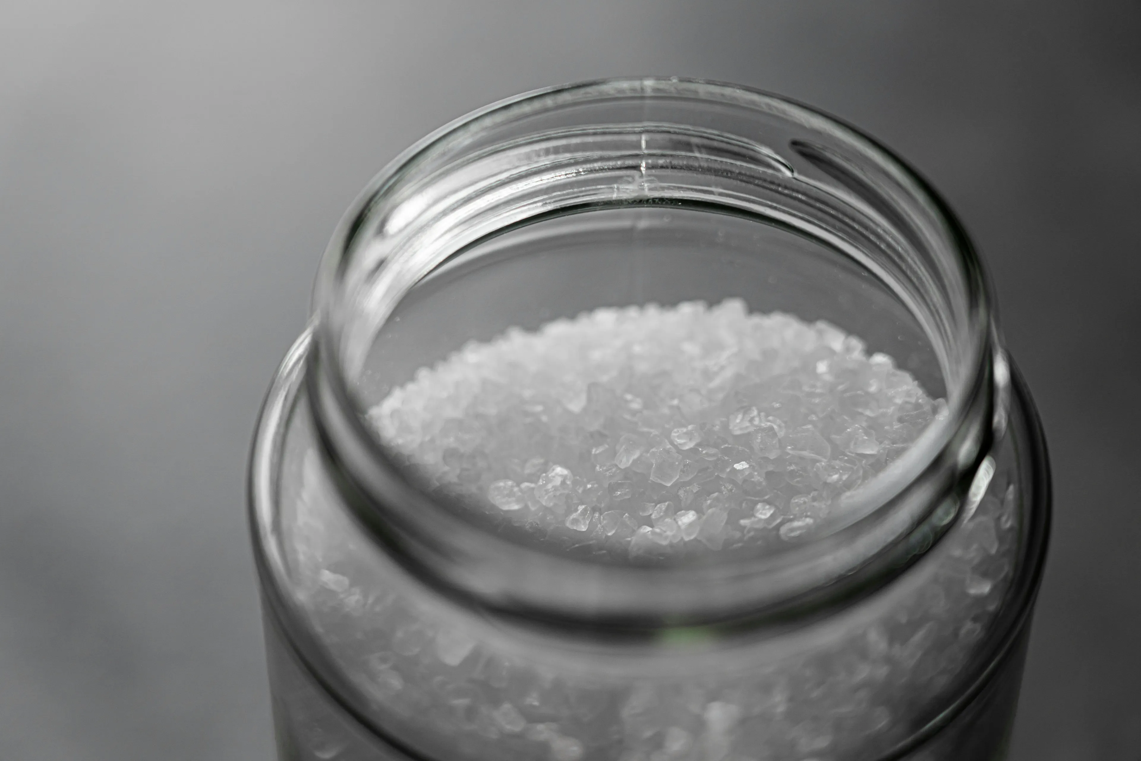 Close-up of salt crystals in a glass jar illustrating salt diffusion and water movement through a semipermeable membrane process