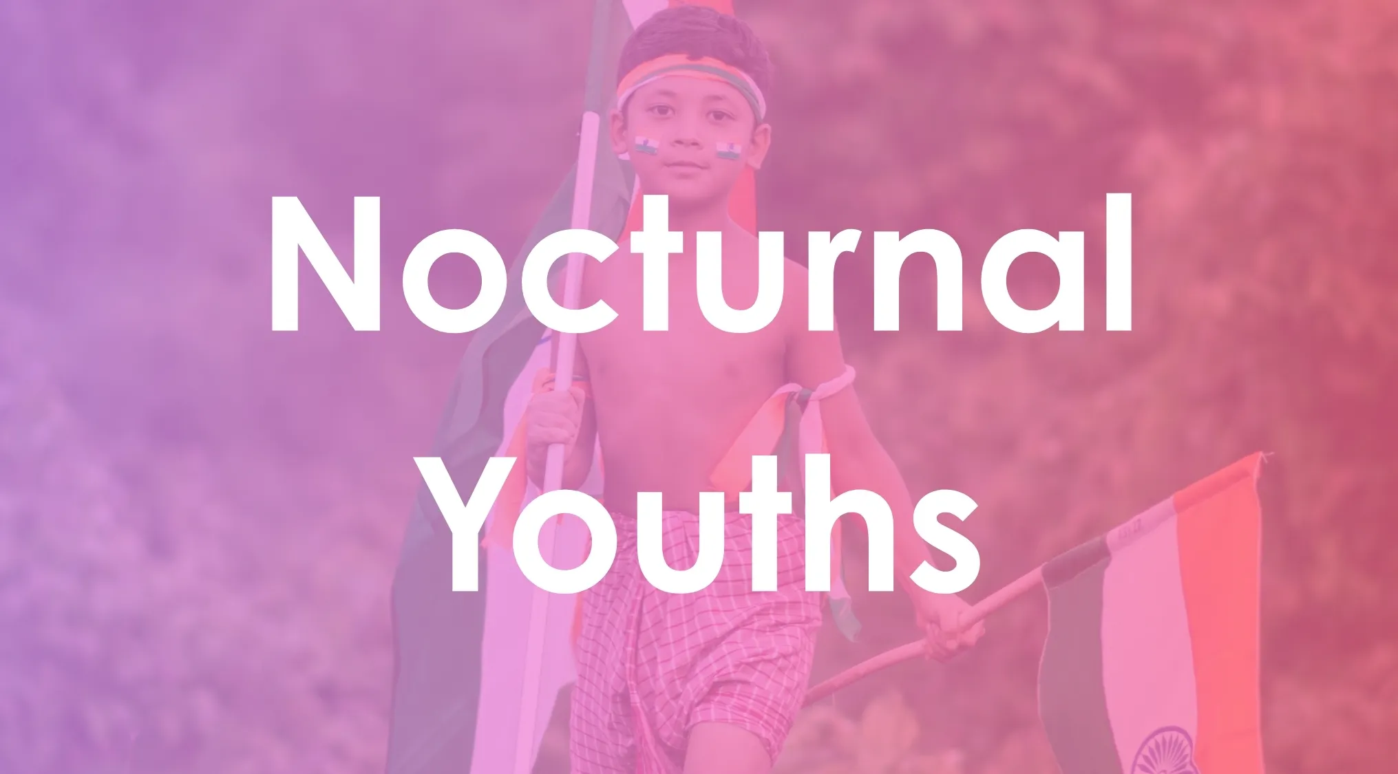 Young boy holding Indian flag, face painted, representing nocturnal youths in patriotic outdoor setting.