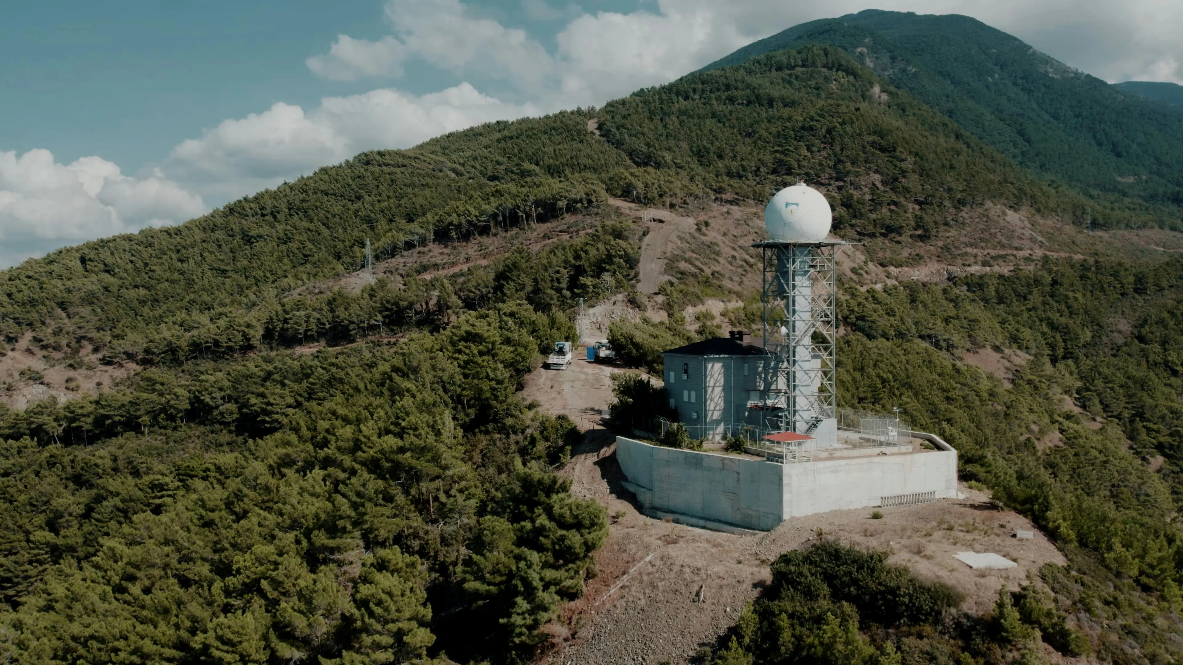 Weather station on a mountain tracking air pressure changes with radar dome instrument predicting storms and weather patterns.