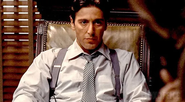 Man in white shirt and suspenders sitting in leather chair, a key Who Wants To Be A Millionaire character with intense gaze.
