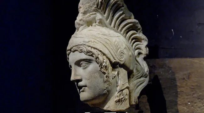 Ancient marble statue of the Greek god of war with a detailed helmet, representing war and mythology.