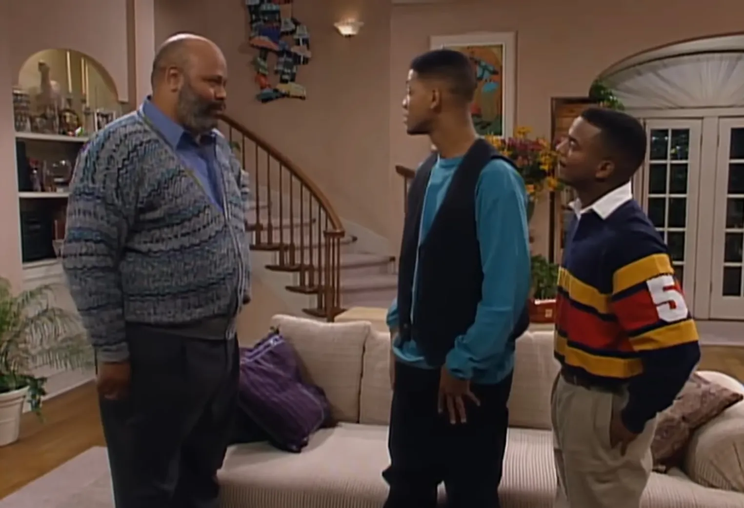 The Banks family in a living room scene with three men engaged in conversation on a TV show set.