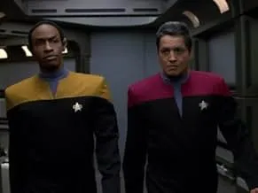 Two Star Trek officers in uniform walking through a dimly lit space station corridor, referencing Star Trek series setting.