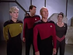 Crew members of a Star Trek series wearing starfleet uniforms standing inside a space station corridor.