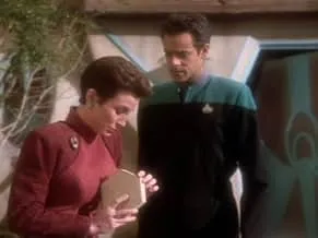 Star Trek Deep Space Nine characters in uniform on a space station, engaged in a focused conversation.