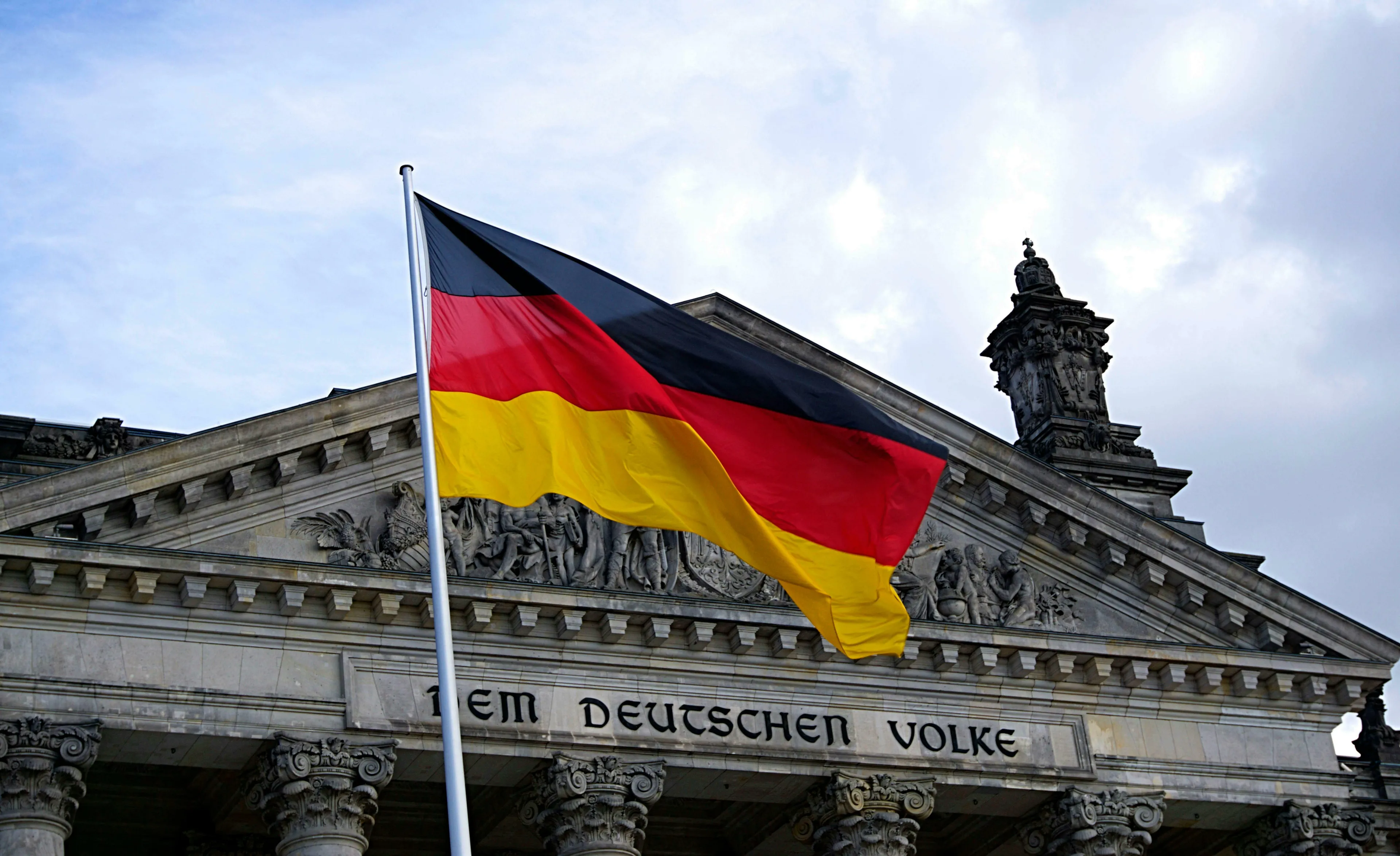 German flag waving in front of a historic building, representing German crime series and police teams in various cities.