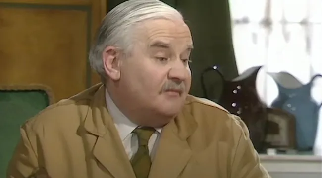 Main character from Open All Hours comedy running a small corner shop in a classic 80s and 90s TV scene.