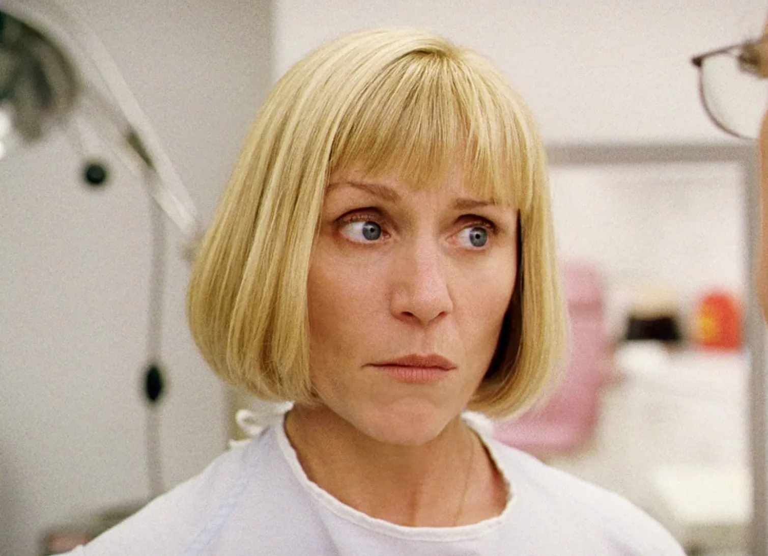 Frances McDormand with blonde bob haircut, wearing white, portraying a lead role in Midsommar 2019 film scene.