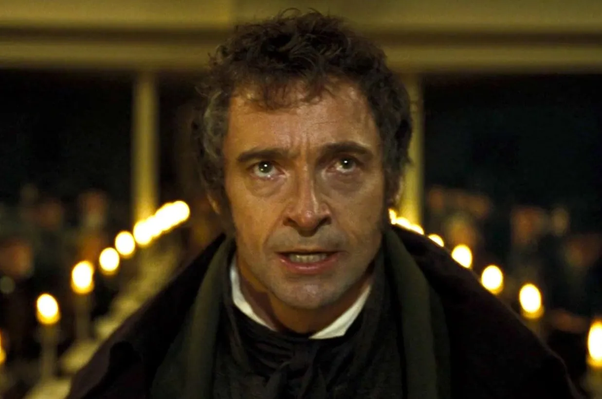 Close-up of a man with intense expression in a dimly lit room, unrelated to who played The Joker in The Dark Knight.