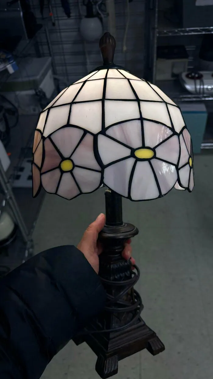 Hand holding a vintage stained glass lamp found at a thrift store, a true jackpot.
